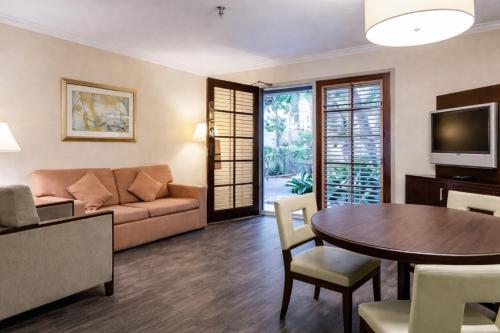 a living room with a couch and a table at The Buena Park Grand Hotel & Suites in Buena Park