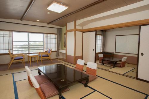 a meeting room with a table and chairs and a chalkboard at Ikaho Onsen Todoroki in Shibukawa
