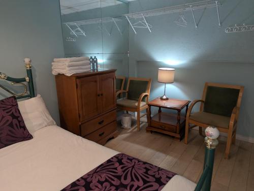 a bedroom with a bed and two chairs and a table at Calgary Star Cozy Home in Calgary