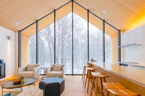 a room with a large window with a table and chairs at Kouzan Woods in Kaributo