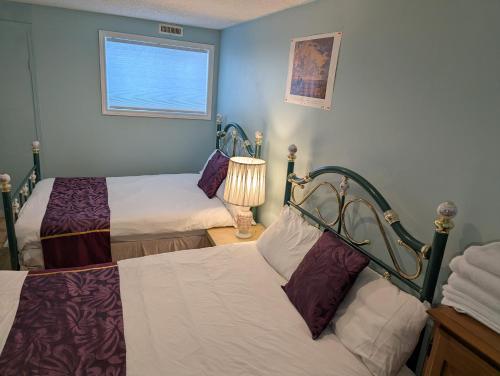 a room with two beds and a window at Calgary Star Cozy Home in Calgary
