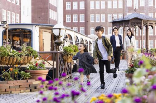 a group of people walking on a bridge with flowers at Hotel Europe Huis Ten Bosch in Sasebo
