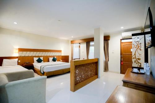 a hotel room with two beds and a couch at Cakra Kembang Hotel in Yogyakarta