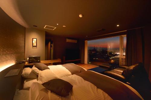 a bedroom with a large bed and a large window at Business Resort Kyuan in Oita