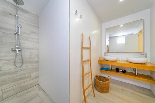 a bathroom with two sinks and a shower at Deva Beach Boutique Apartments in San Bartolomé