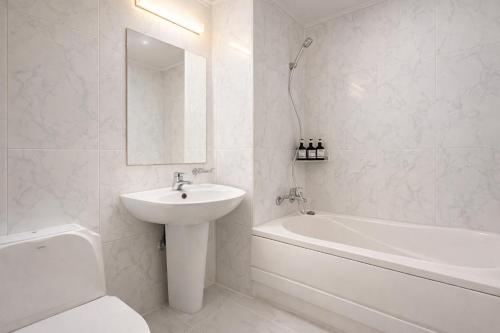 a white bathroom with a sink and a bath tub at 평촌코아 in Mabun-ni
