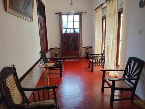 a living room with chairs and a table and a window at The Garden Villa in Matara