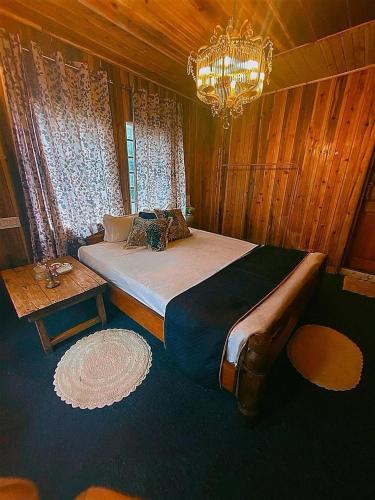 a bedroom with a large bed and a chandelier at Lee's Grandma's Will Cottage in Kalimpong