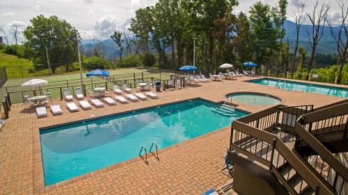 a swimming pool with lounge chairs and umbrellas at City View Chalet, City View Chalet, Pool Table, Hot Tub, WIFI, Free Attraction Tickets!!! in Gatlinburg