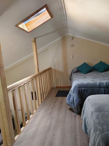 a attic bedroom with two beds and a skylight at Loft Volcan Villarrica in Licán Ray