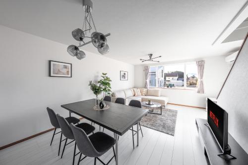 a living room with a dining room table and chairs at Hills Niseko C in Niseko