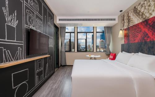a bedroom with a large white bed and a tv at 宜必思昆明火车站酒店Ibis Kunming Railway Station in Kunming