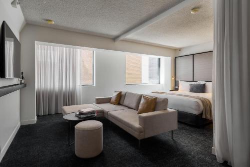 a hotel room with a bed and a couch at Lancemore Crossley St. Melbourne in Melbourne