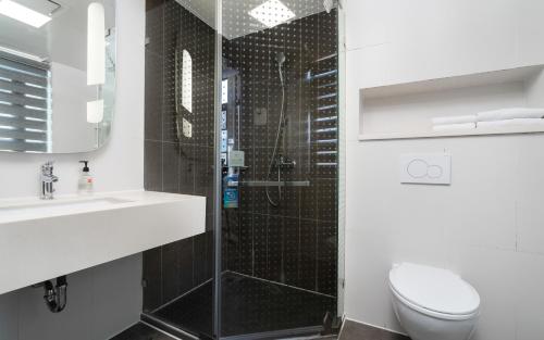 a bathroom with a shower and a toilet and a sink at 宜必思昆明火车站酒店Ibis Kunming Railway Station in Kunming