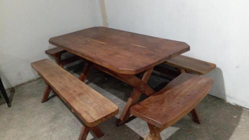 a wooden table and a pair of wooden benches at Casa com piscina in Marechal Deodoro