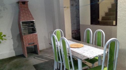 a table and chairs in a room with a pizza oven at Casa com piscina in Marechal Deodoro