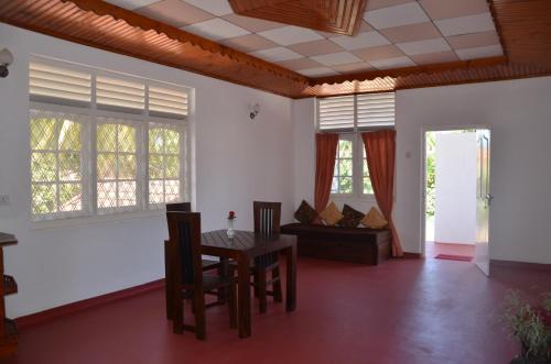 een woonkamer met een tafel, stoelen en een bank bij Roel Rest in Negombo