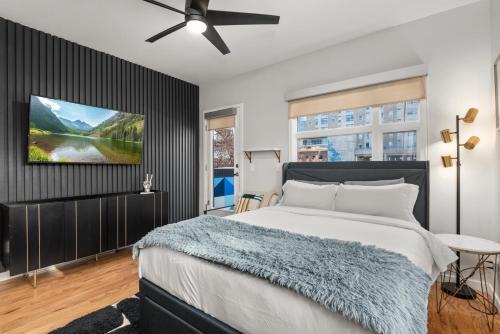 a bedroom with a bed and a tv on a wall at Rooftop Retreat with Workspace and BBQ in Denver