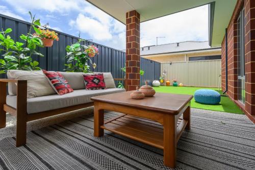 a patio with a couch and a coffee table at 42 Coogee Beach Marina 3BR Haven near Omeo Wreck in Coogee