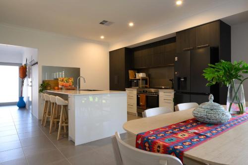 a kitchen and dining room with a table and chairs at 42 Coogee Beach Marina 3BR Haven near Omeo Wreck in Coogee