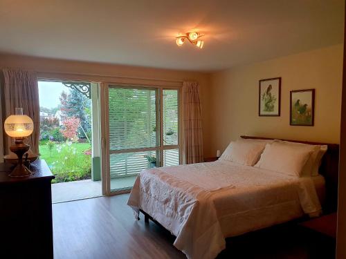 a bedroom with a bed and a large window at Lily Pad Apartment in Motueka