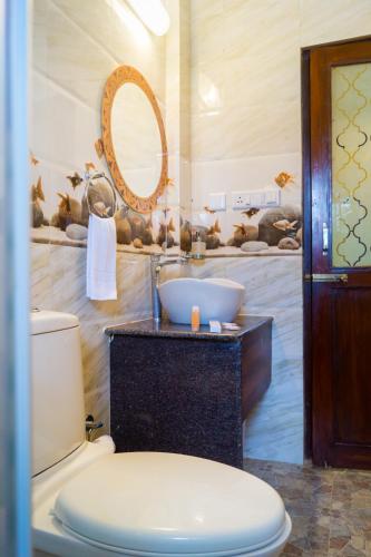 a bathroom with a toilet and a sink and a mirror at Jacks Resort in Vagator