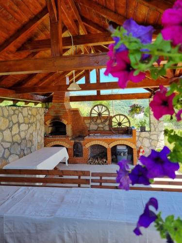 a patio with a fireplace and a bench and flowers at Pensiune La Becu in Vidra
