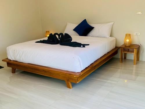 a bedroom with a bed with a black robe on it at GOODNIGHT Hill KOHYAOYAI in Ban Nai Wat