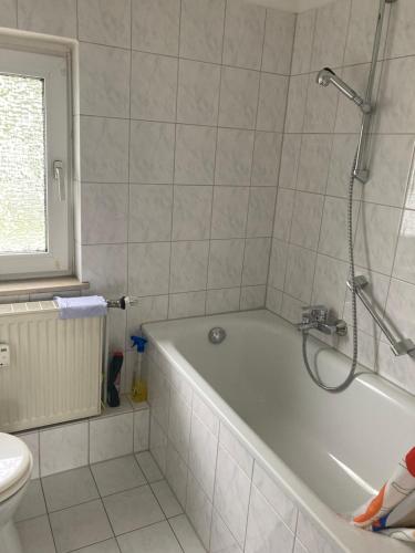 a bathroom with a bath tub and a toilet at Self check in ganzes Apartment 40 m zwei Schlafzimmer Wlan Parkplatz eigenes Badezimmer mit Badewanne Kochecke Einfamilienhaus in Duisburg