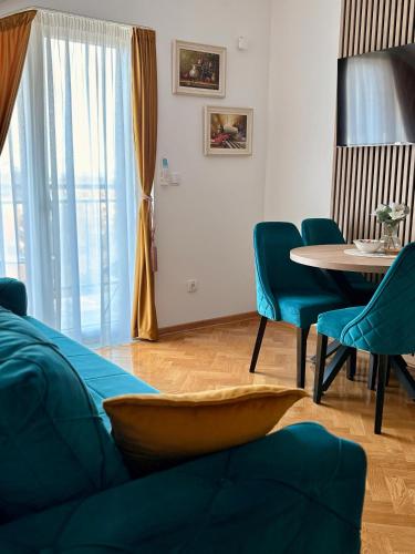 a living room with a couch and a table and chairs at Aurora Lux in Vrnjačka Banja