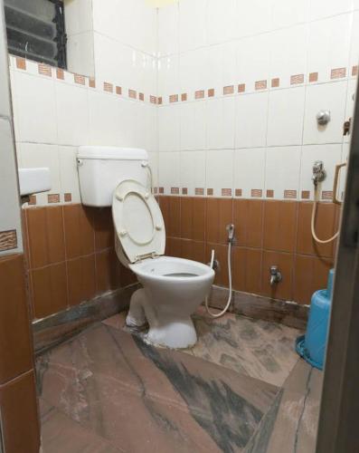 a bathroom with a toilet with the lid up at Hotel Moon N' Net in Digha