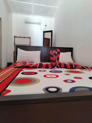 a bed with a colorful blanket on top of it at The Heritage Hotel in Polonnaruwa