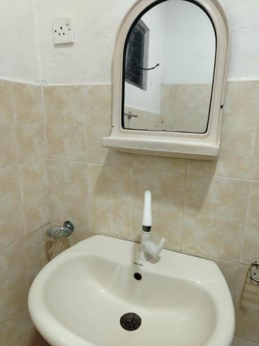 a white sink in a bathroom with a mirror at The Heritage Hotel in Polonnaruwa