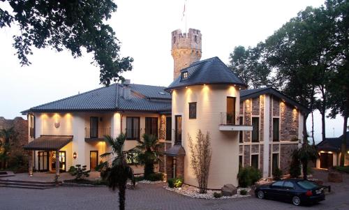 a house with a chimney with a car parked in front of it at Burg & Gästehaus by Schwarzenstein in Geisenheim