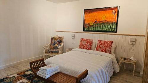 a bedroom with a bed and a chair and a painting at The loft - A charming sanctuary in Rivière Noire