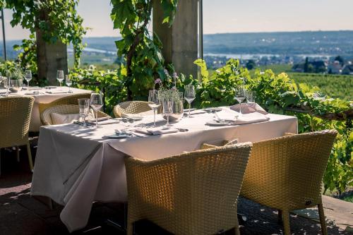 a table with chairs and wine glasses on top of it at Burg & Gästehaus by Schwarzenstein in Geisenheim
