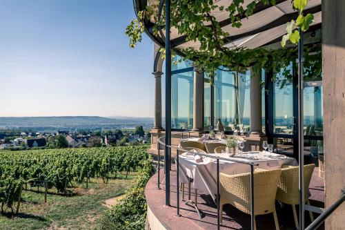 a restaurant with tables and chairs and a vineyard at Burg & Gästehaus by Schwarzenstein in Geisenheim