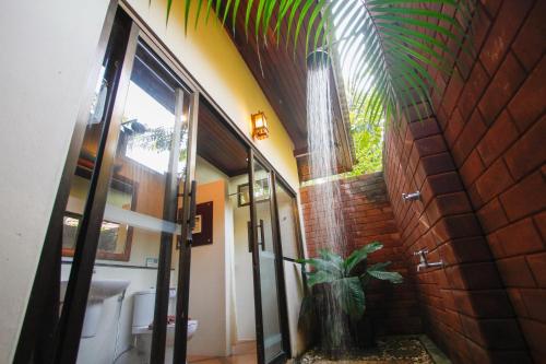 a bathroom with a glass door with a plant in it at Baan Grood Arcadia Resort & Spa in Ban Krut