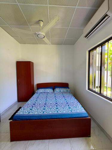 a bed in a room with a ceiling fan at Villa Octopus in Maggona West