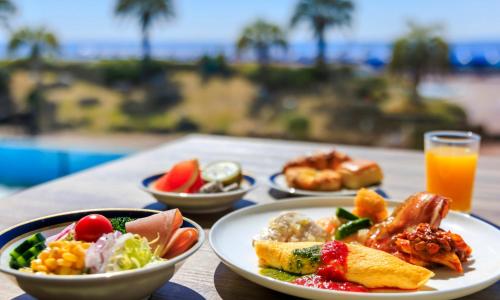 a table with plates of food and a glass of orange juice at Oiso Prince Hotel in Oiso