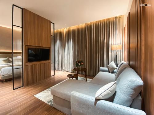 a living room with a couch and a tv and a bed at Hotel Aamodh in Lucknow