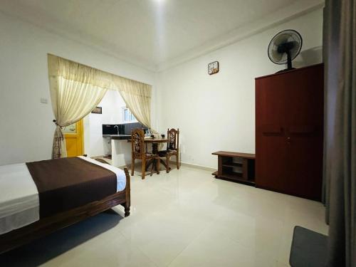 a bedroom with a bed and a desk and a table at Kandyan Gate Homestay in Kandy
