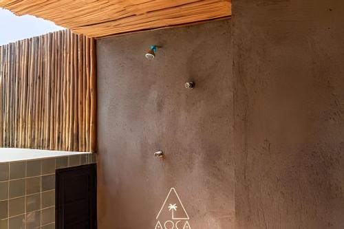 a bathroom with a concrete wall with aperature at Aluá Patacho in Pôrto de Pedras