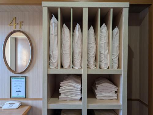 a closet filled with white towels and a mirror at Green Rich Hotel Aso Kumamoto Airport (Artificial hot spring Futamata Yunohana) in Kikuchi