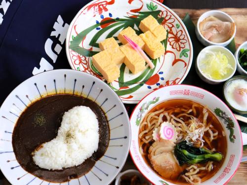 a table topped with plates of food and bowls of noodles at APA HOTEL Fukushima Ekihigasi in Fukushima