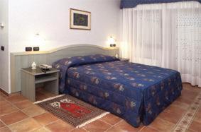 ein Schlafzimmer mit einem Bett und einem Tisch in einem Zimmer in der Unterkunft Hotel San Giorgio in Sangano