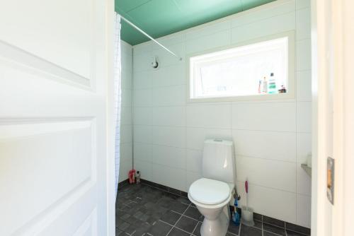 a bathroom with a toilet and a window at The Greenhouse in Eggum