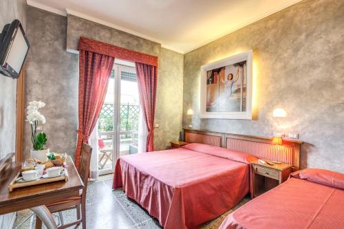 a hotel room with two beds and a window at Domus Caracalla in Rome