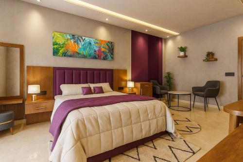 a bedroom with a large bed with a purple headboard at Truva Hotel in Faridabad