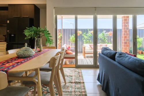 a living room with a table and a blue couch at 42 Coogee Beach Marina 3BR Haven near Omeo Wreck in Coogee